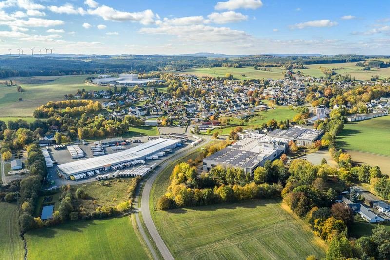 Luftaufnahme von Konradsreuth mit Gewerbegebiet, Wohnhäusern und Herbstlandschaft