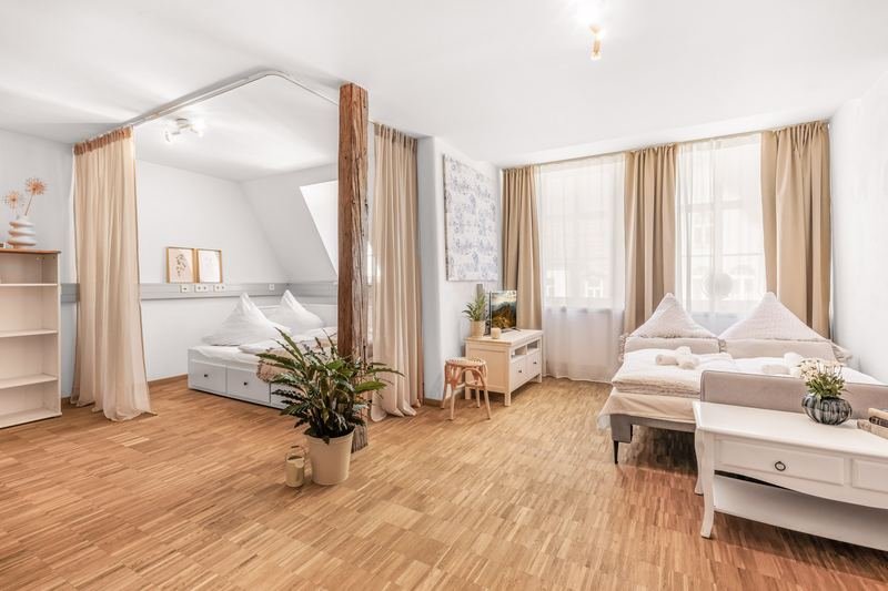 Helles Apartment mit Dachschräge, Bett und Holzboden