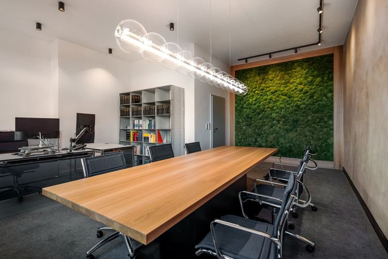 Besprechungsraum einer Notarkanzlei in Hof mit Holztisch, Mooswand und Glasleuchte, Innenarchitektur PlanKult