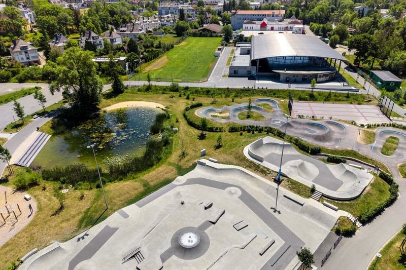 Luftbild einer Skateanlage mit Teich und Grünflächen