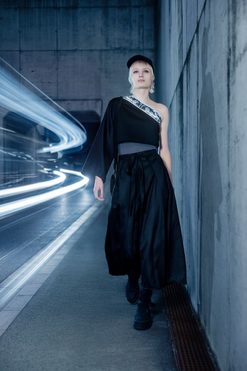 KI-Hybrid-Projekt TSUNAGARI: Model mit Cap in einem Tunnel, Lichtspuren vorbeifahrender Fahrzeuge