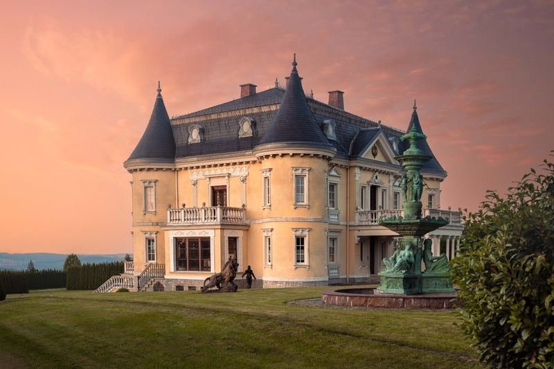 Historische Villa mit Turm und Säulenvorbau im Abendlicht